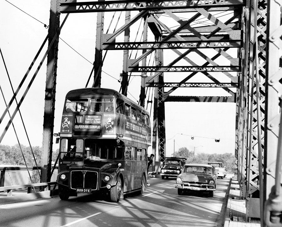 British double-decker squeezes over Ak-Sar-Ben bridge - 1964